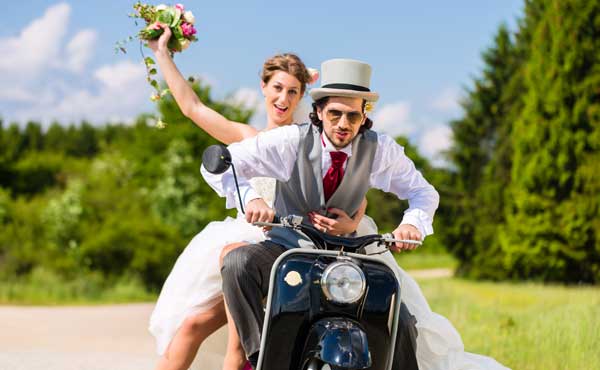結婚衣装でバイクに乗るカップル