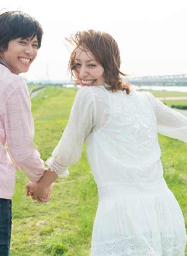 笑いながら手をつなぐカップル