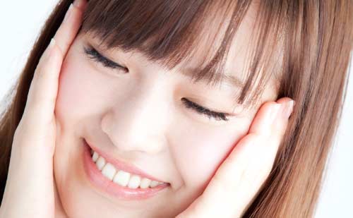 両手を頬にあて照れる女性