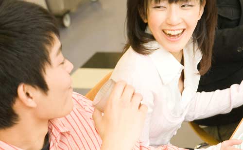 笑顔で男性と会話を楽しむ大学生