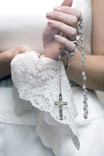 親から貰ったクロスのネックレスを持ってるウェディングドレスを着た新婦