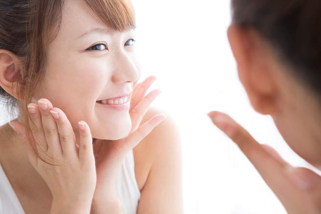 新しい出会いのために笑顔の練習をする女性