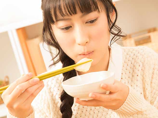 お腹が鳴らないようにゆっくりよく噛んで食べる女性