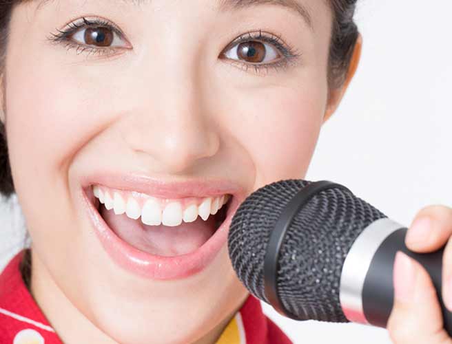 大きく口を開いて歌う女性