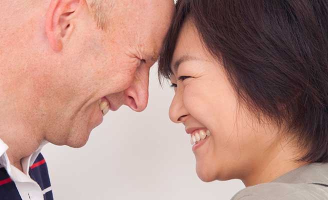 額をつき合わせて笑顔の日本人女性と外国人男性のカップル