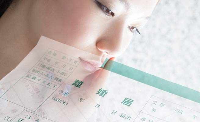 離婚届用紙と思案する女性の顔
