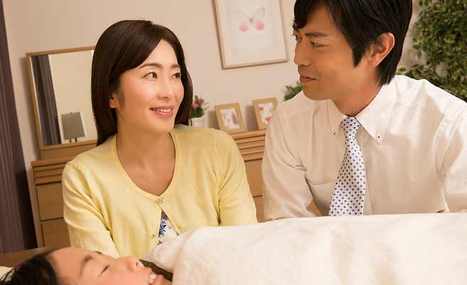 寝ている子供の前で会話する男女