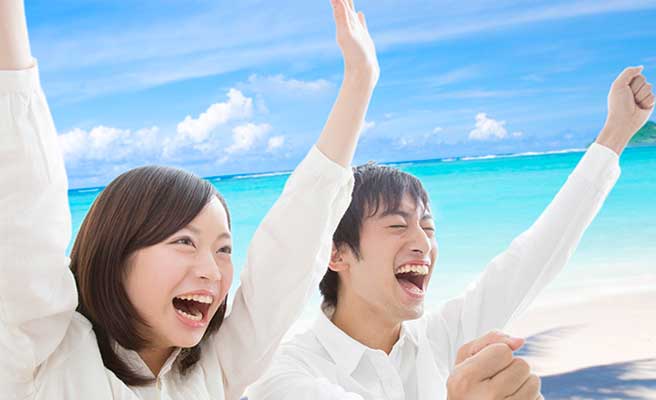 沖縄の青い海に喜ぶカップル