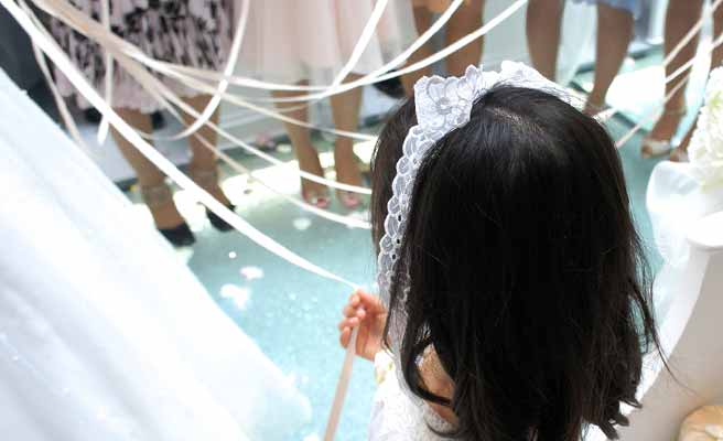 ブーケプルズの紐を握る大人たちに混じって参加する少女