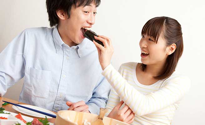 手作り海苔巻きを彼氏に食べさせる女性