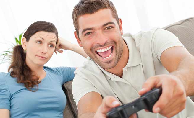 ゲームに夢中な男性を見つめる女子