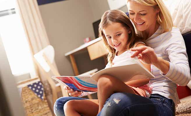 子供を抱きながらノートをめくる母親