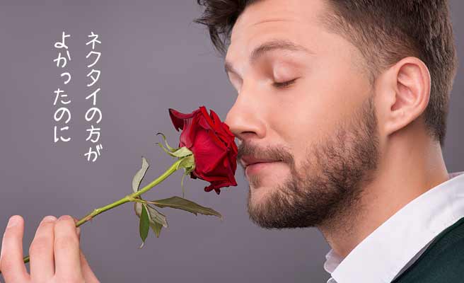 バラの花一輪を自分の鼻先に押し付ける男性