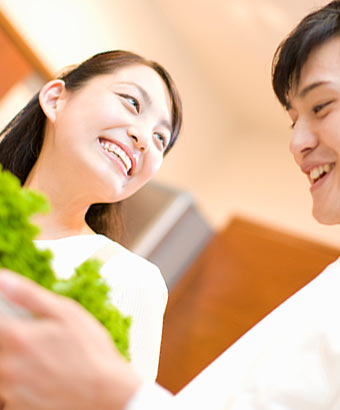 夫婦で野菜を持った皿を運んでいる