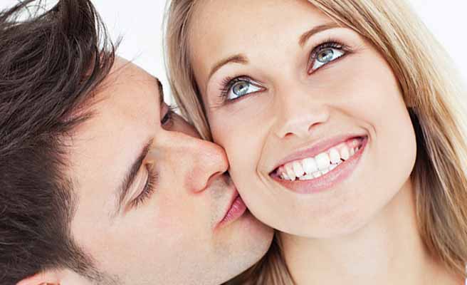 彼女に頬にキスする男性