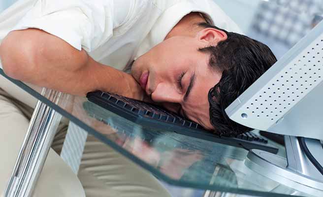 パソコンの前で眠る男性