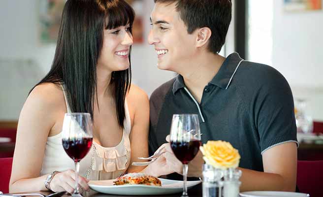 男と食事をしながら体を付ける女性