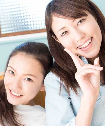 笑顔で友達と寄り添う女性