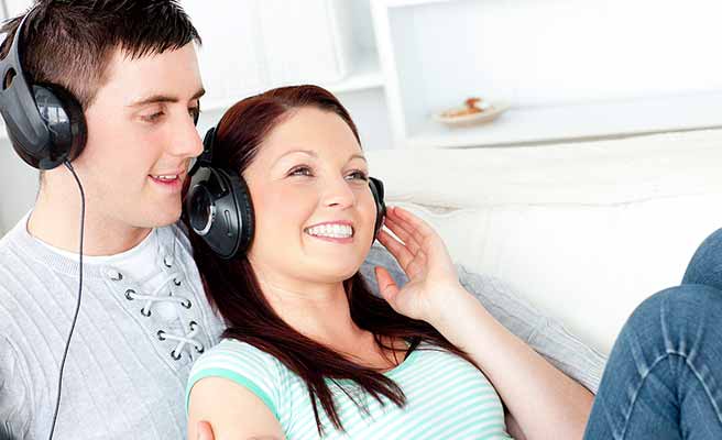 部屋で一緒に音楽を聴くカップル