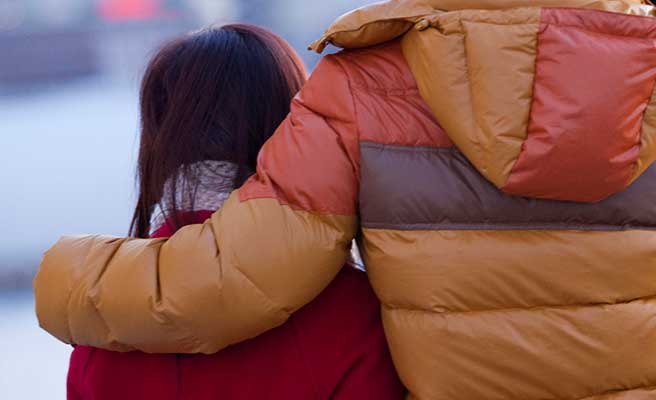 男性に肩を抱かれる女性
