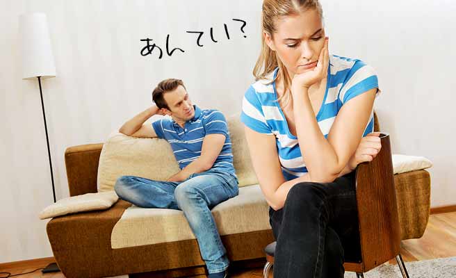 片肘ついて思案する女性と背後の無表情の男性