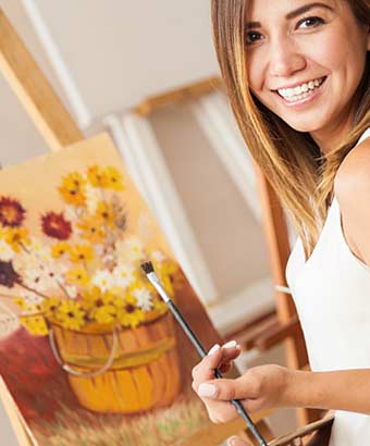筆を手にして油絵を描く女性
