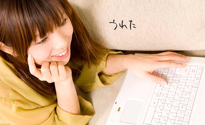 ノートパソコンを見ながら微笑む女性