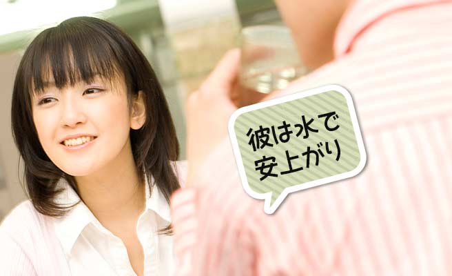 食事の席で水を飲む男性と笑顔の女性