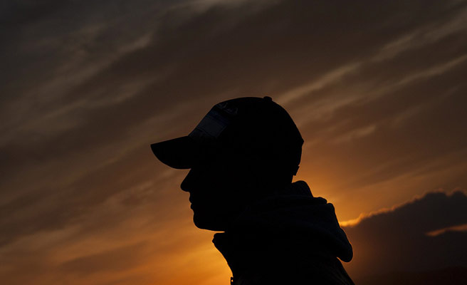 夕刻の空を背景に立つ男性の影