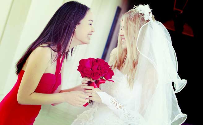ウェディングドレスを着た新婦と話をしているブライズメイド