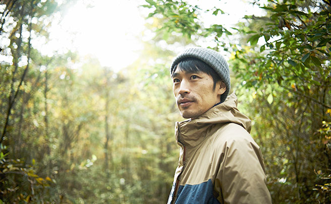 林の中で誰かを見つめる男性