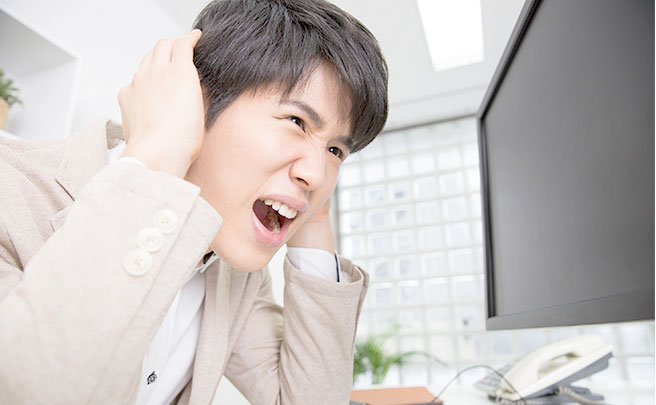 仕事でプレッシャーを感じ頭を抱えている男性
