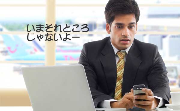 パソコンがしたいのにケータイに連絡が入った男性